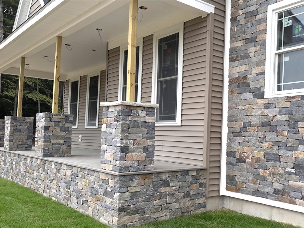 Stone veneer applied to porch columns and the foundation skirt of a house with siding above
